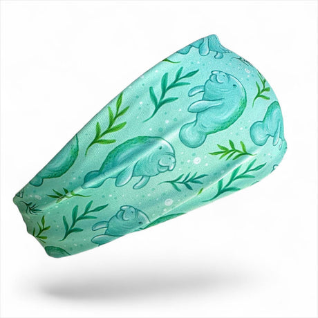 Turquoise headband with manatee and leaf pattern on a white background
